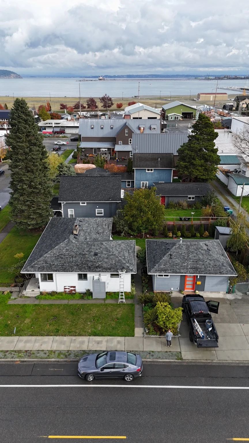 Vertical aerial photograph of the finished Anacortes roofing project with the waterfront in the background