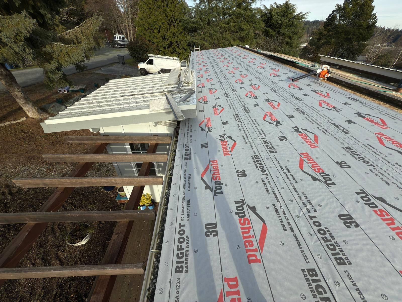 Underlayment covering the new decking during the white PVC roofing project