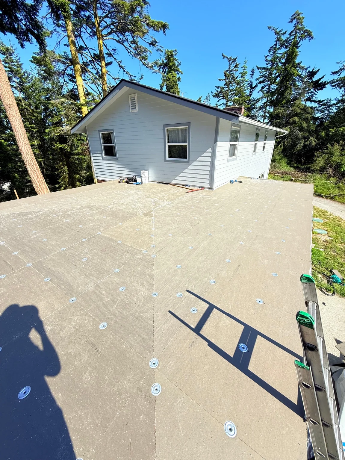 Wide view of the prepared low-slope roof surrounding the upper story of the Oak Harbor home