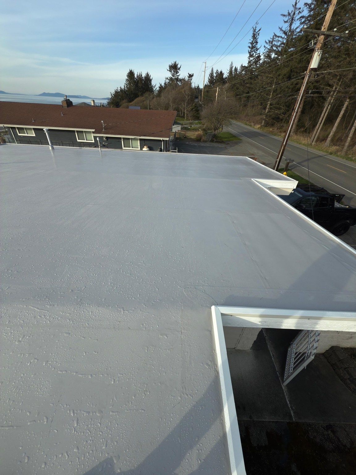 Finished gray PVC membrane and perimeter flashing around the stepped roof corners