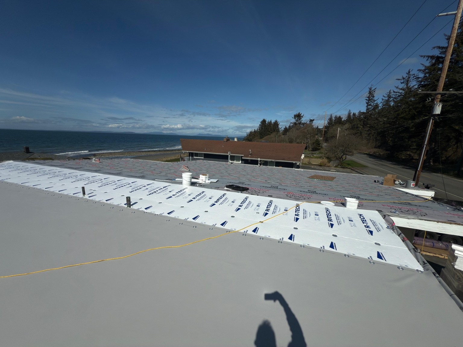 Fan-fold insulation, underlayment, and gray PVC membrane visible during installation